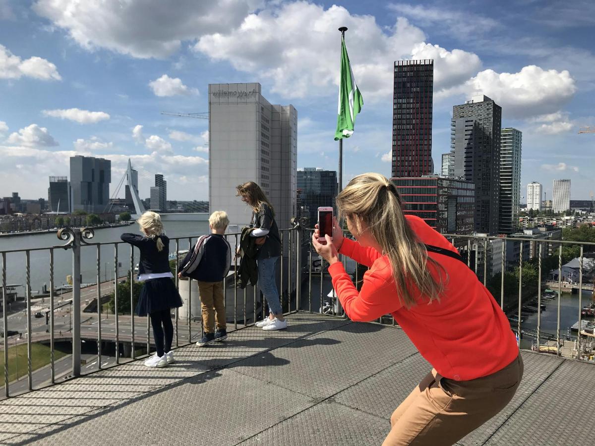 una donna che scatta una foto a un gruppo di persone su un ponte