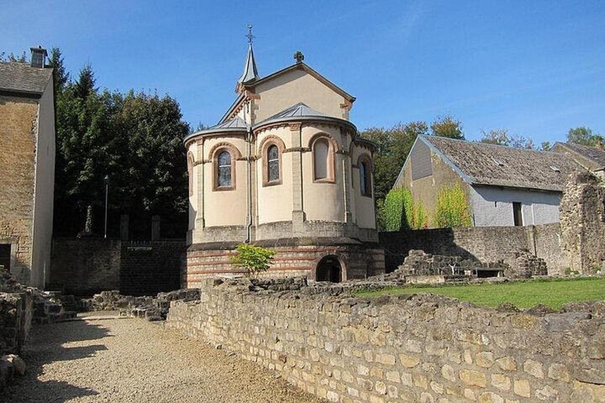 an old building with a cross on top of a stone wall