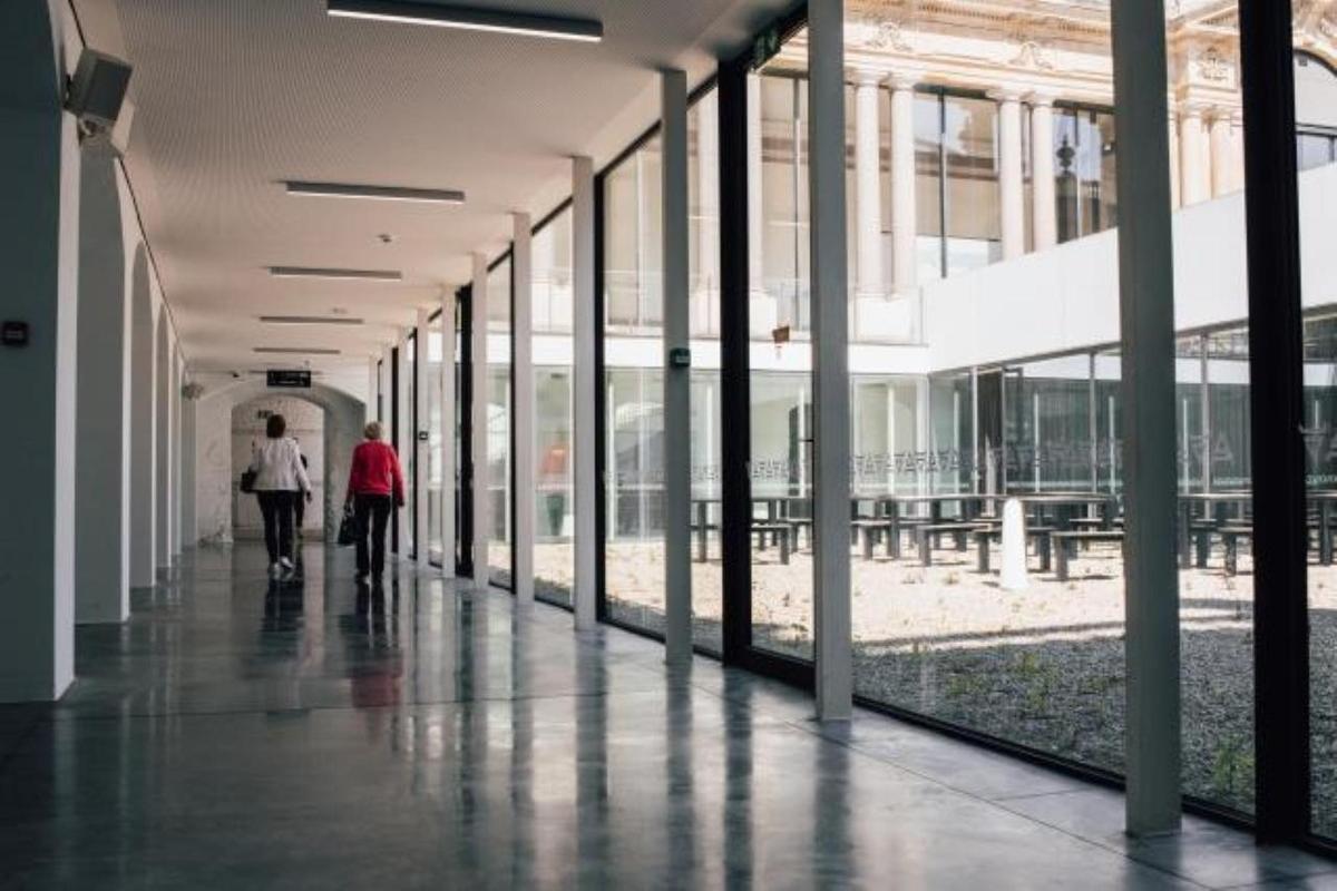 Δύο άτομα περπατούν σε έναν διάδρομο σε ένα κτίριο