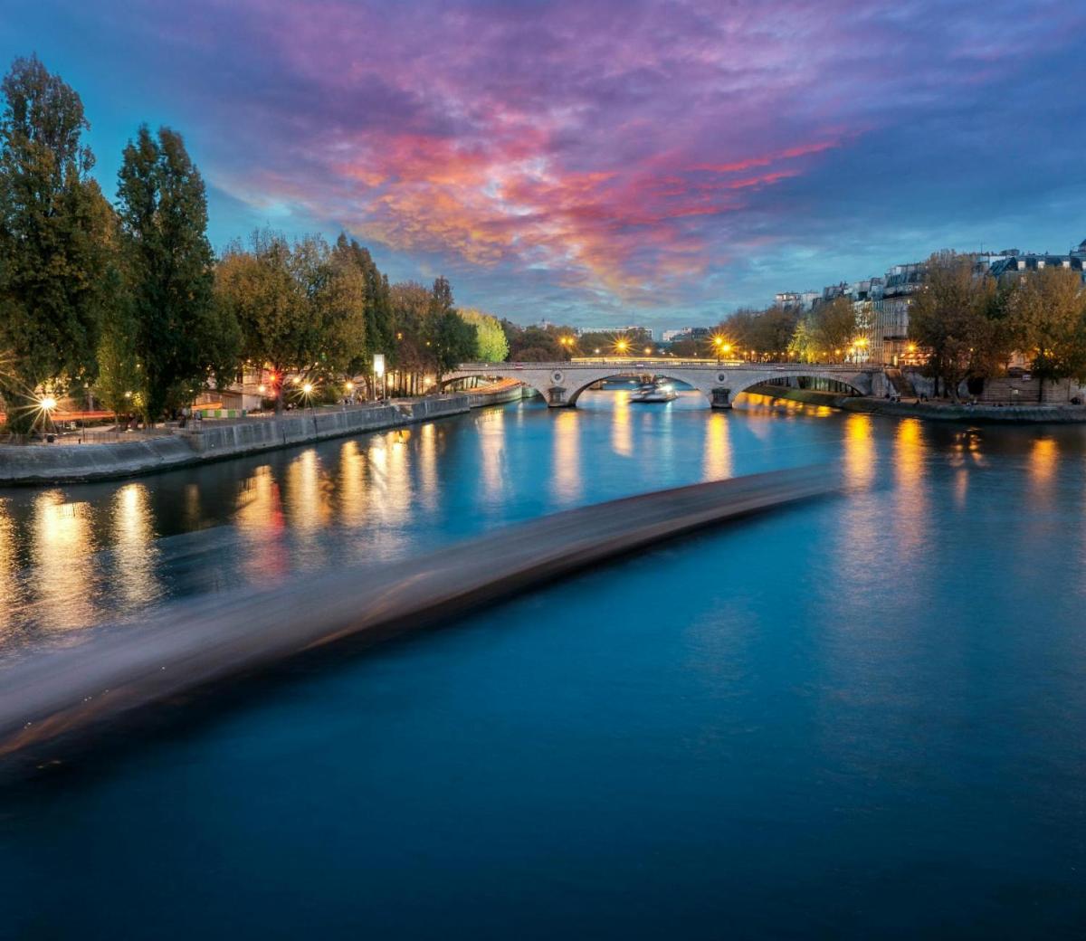 a view of a river at night with a bridge