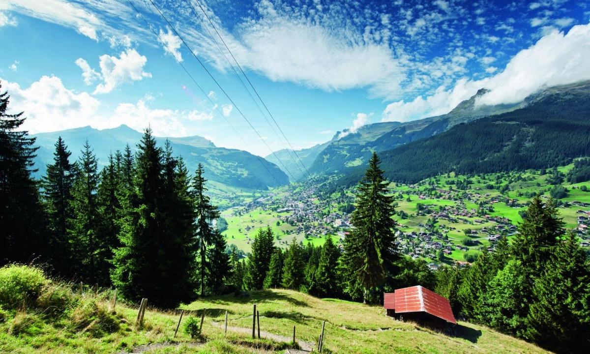 a valley in the mountains with a small house on a hill