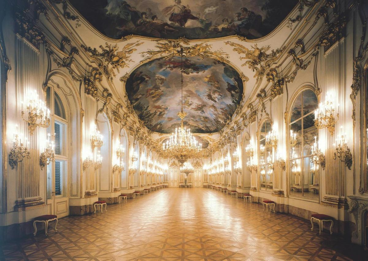 un corridoio di un palazzo con un dipinto sul soffitto