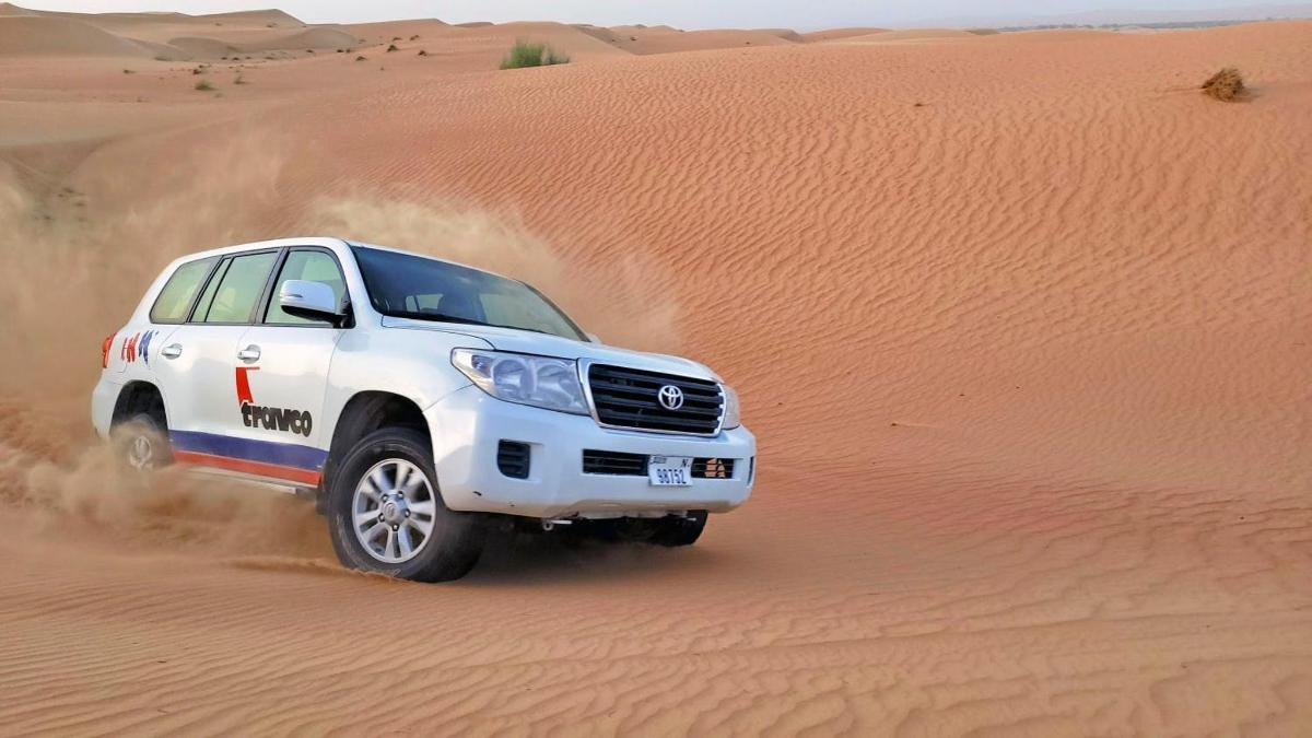 a white truck driving through the desert