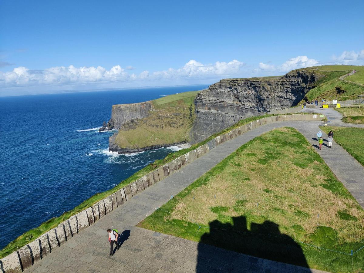 a shadow of a person standing on a cliff near the ocean