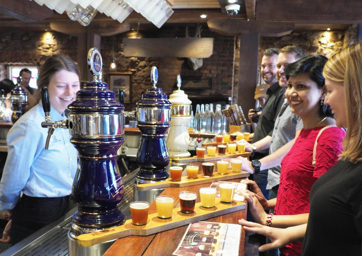 hópur fólks stendur við bar með drykki