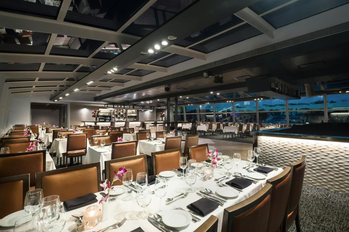 Un comedor con mesas y sillas blancas.