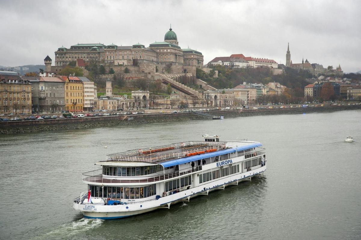 ein Kreuzfahrtschiff auf dem Fluss vor einer Stadt