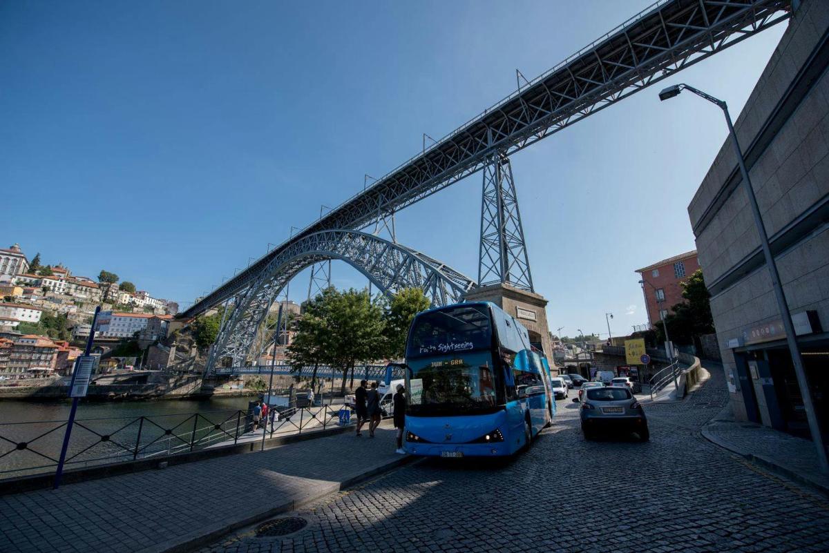 Modri avtobus se pelje pod mostom