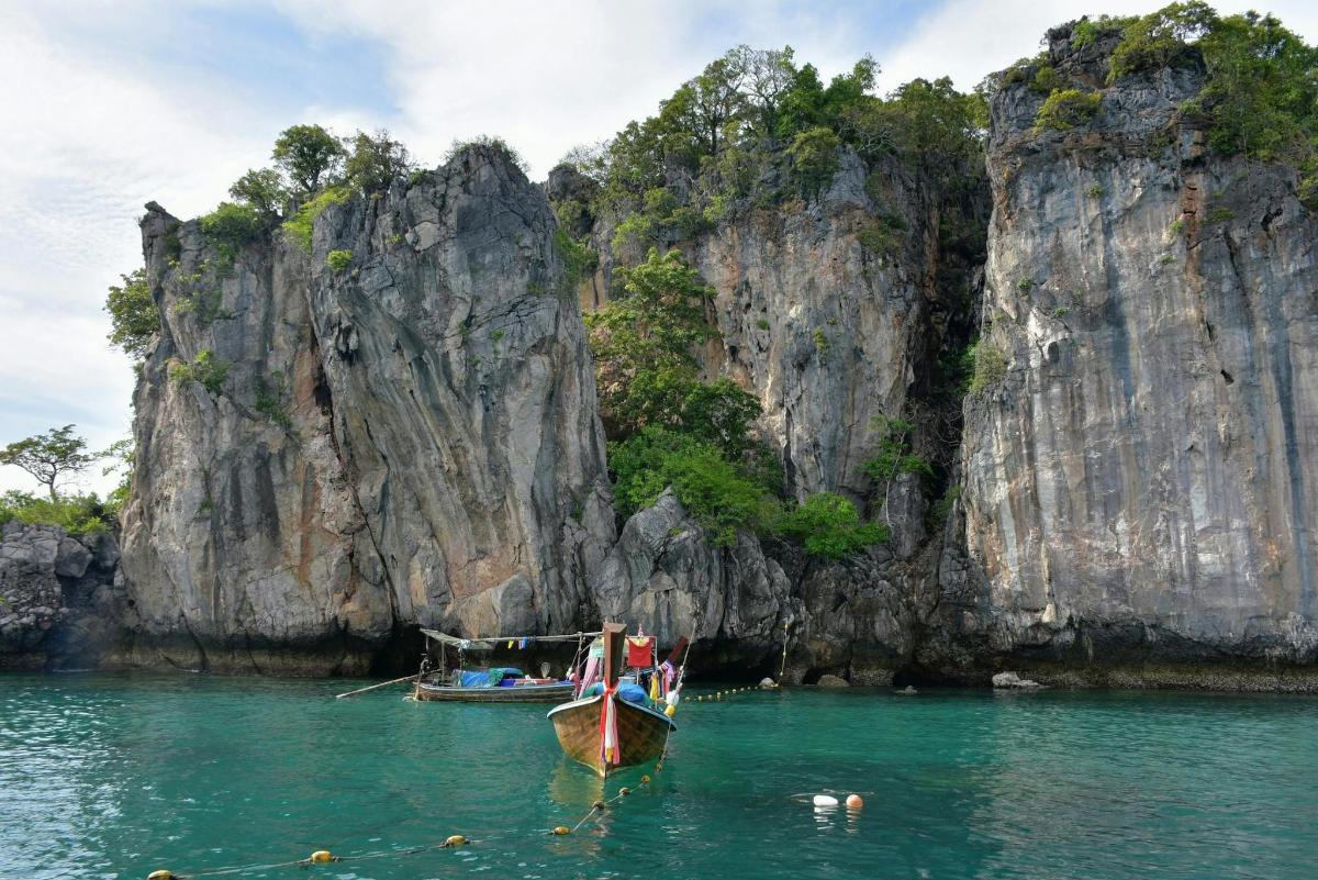 two boats in the water in front of a mountain