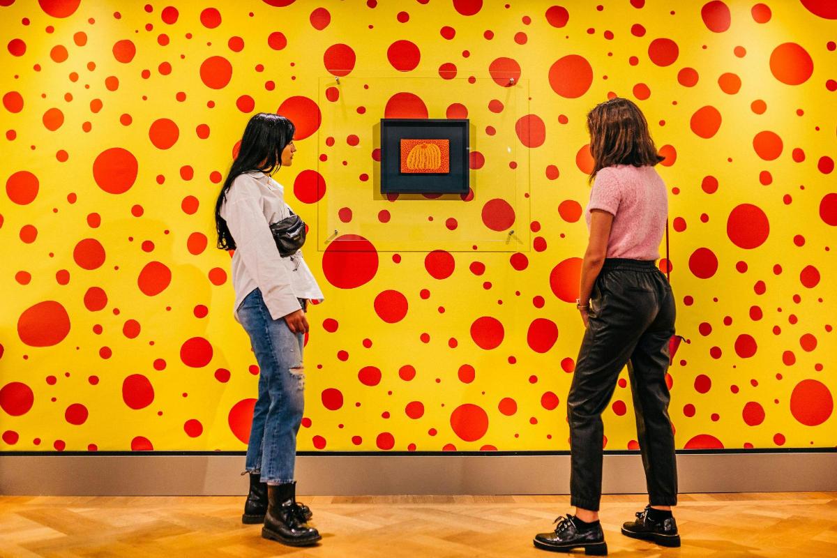 two people standing in front of a wall with polka dots