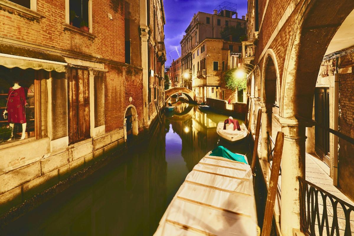 a boat is docked in a canal between two buildings