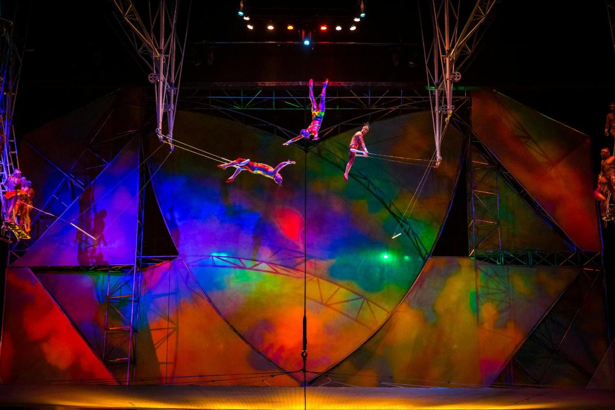 a group of people jumping off a circus tent