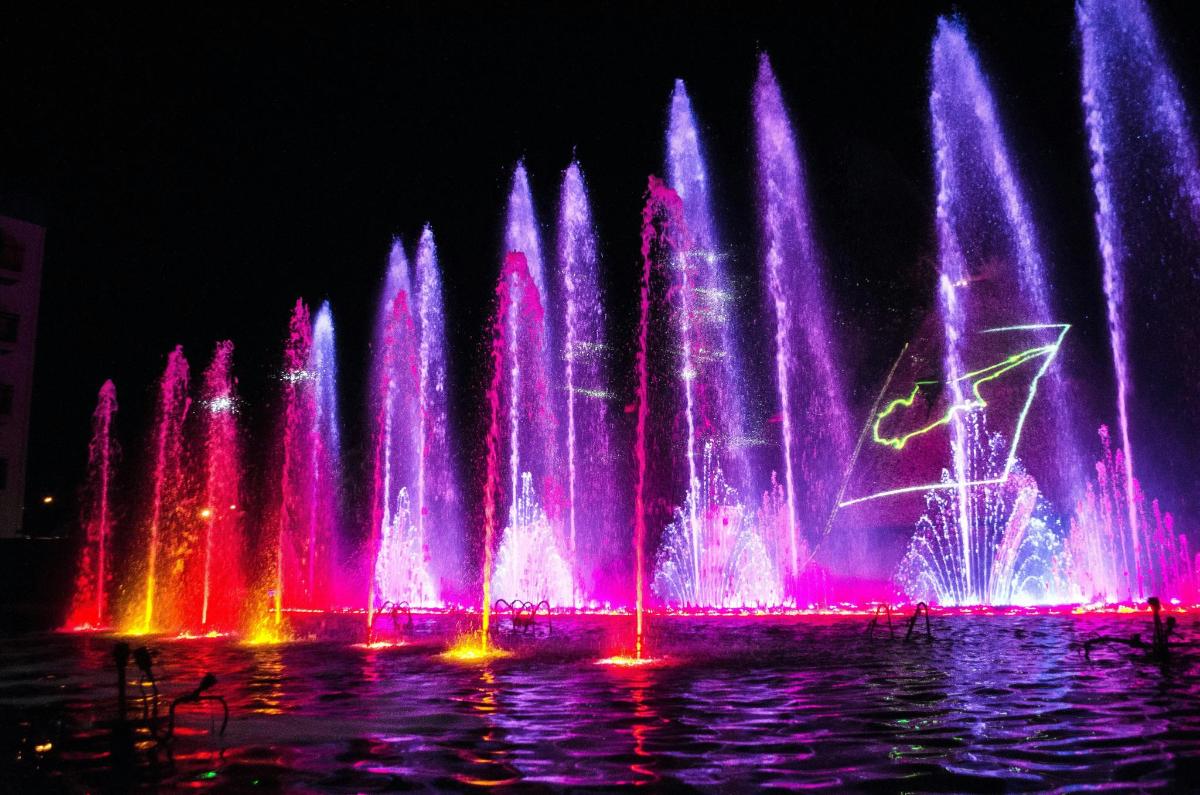 a large water fountain with pink and purple lights