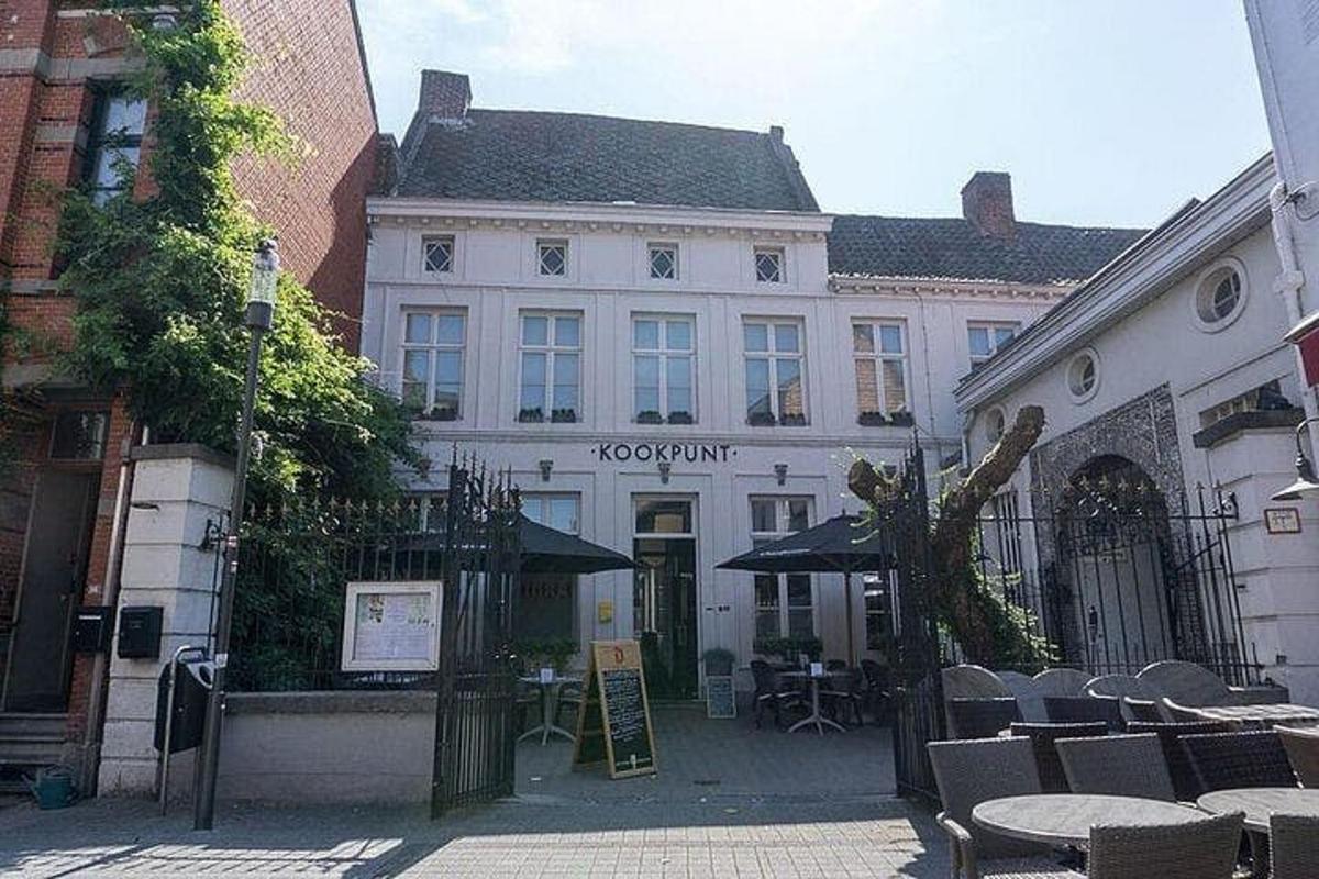 a white building with tables and chairs in front of it