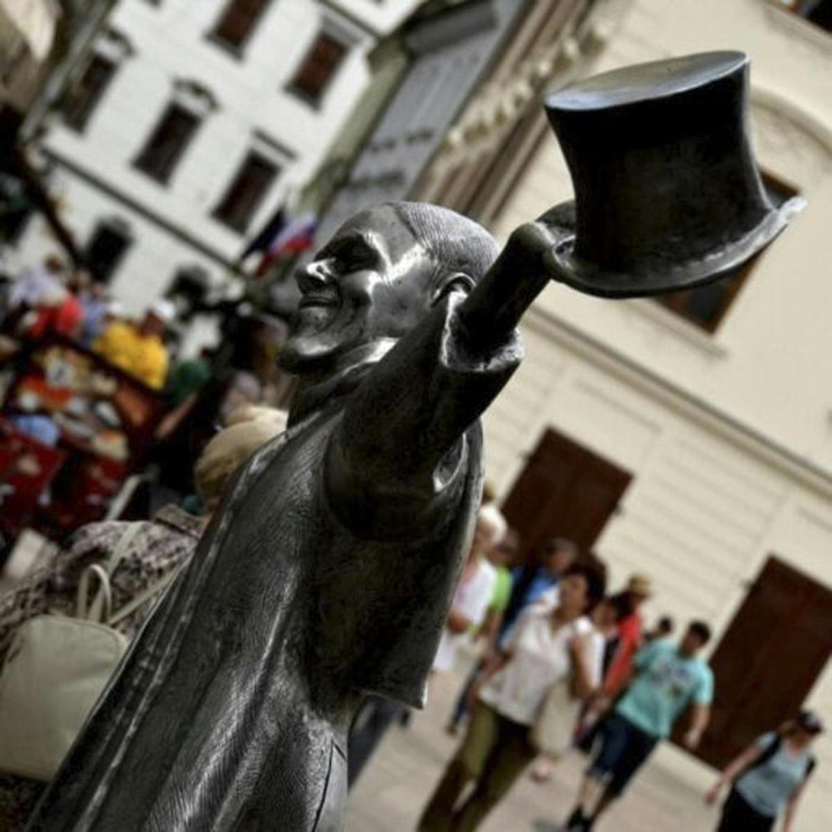 una estatua de una persona sosteniendo un sombrero de copa