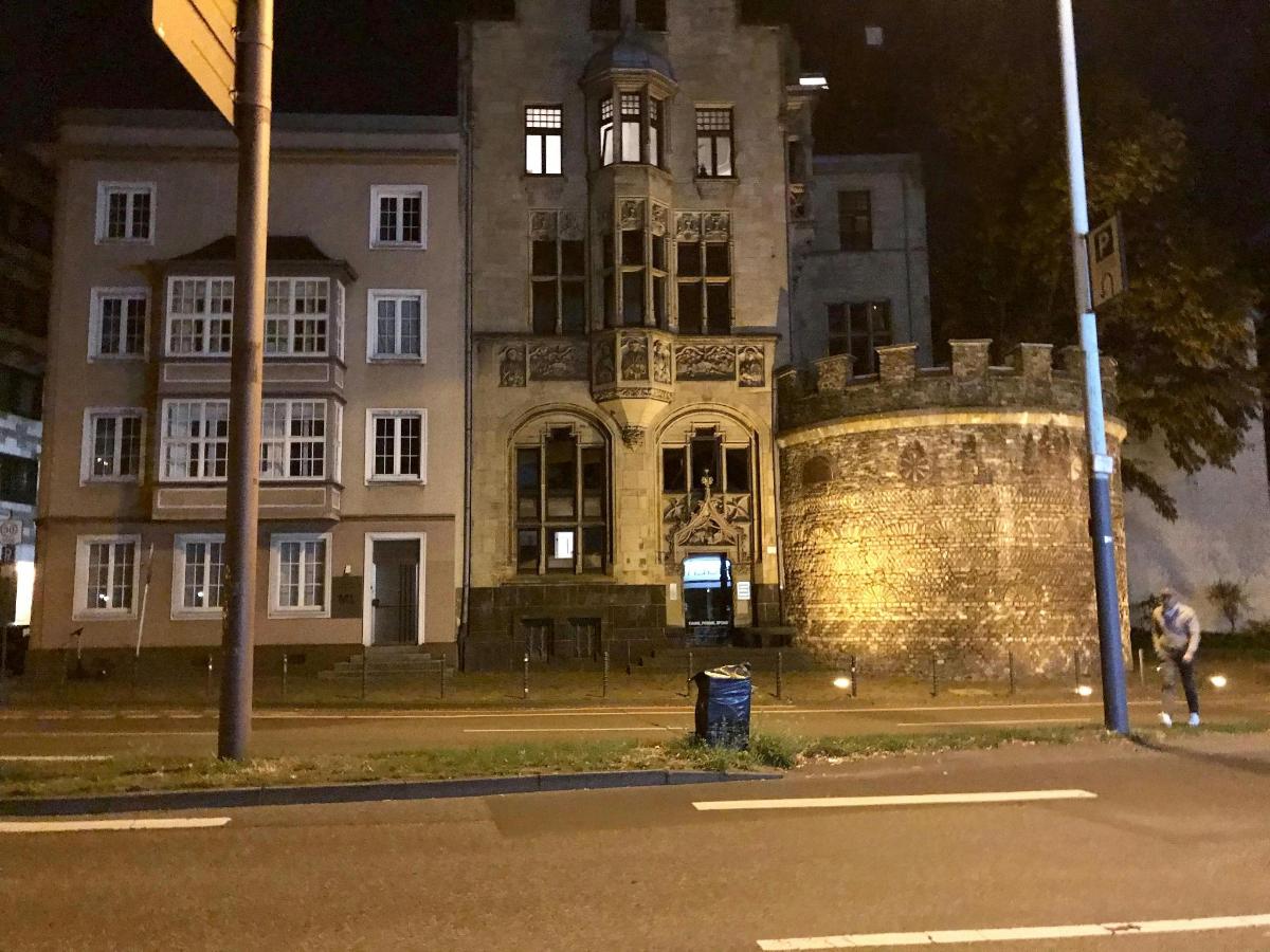 un vecchio edificio di notte con una persona che cammina davanti