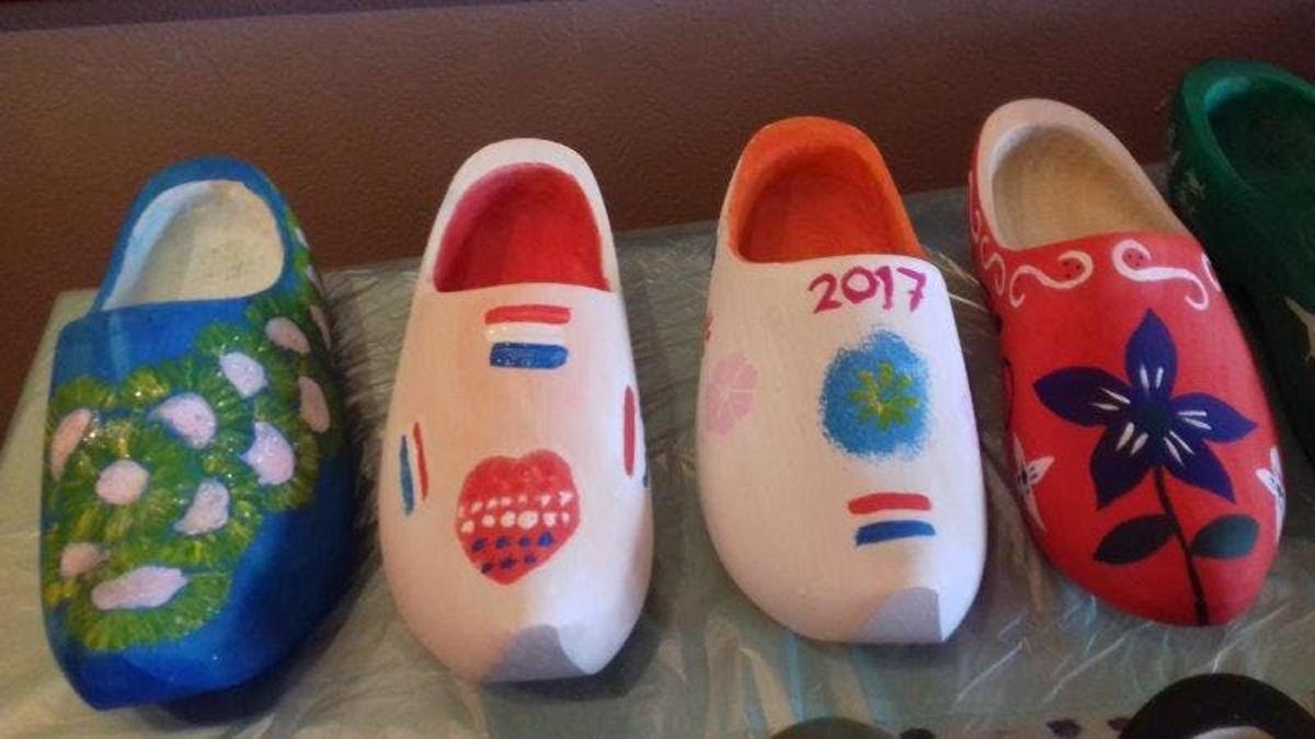 група з чотирьох розфарбованих черевиків, що сидять на столі