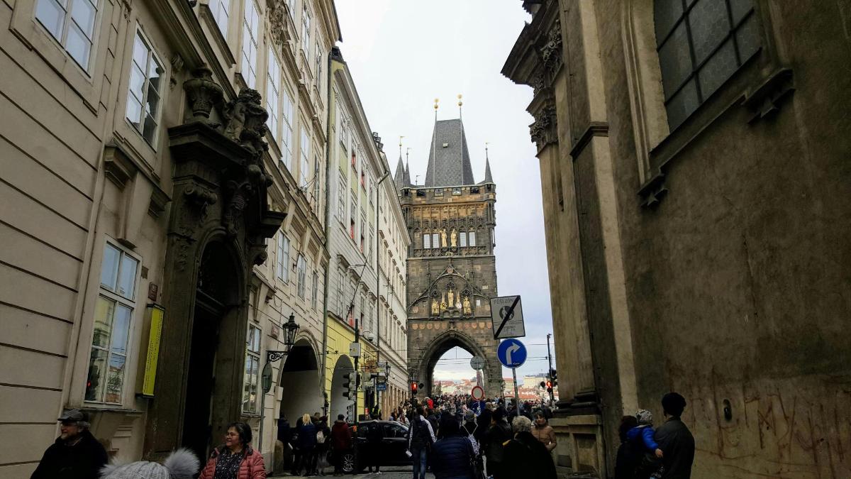 un gruppo di persone che camminano lungo una strada con una torre