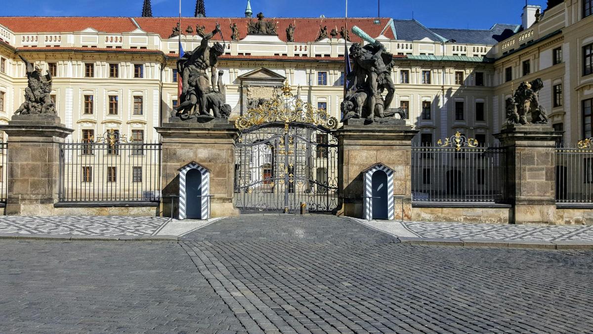 un grande edificio con un cancello con statue di cavalli