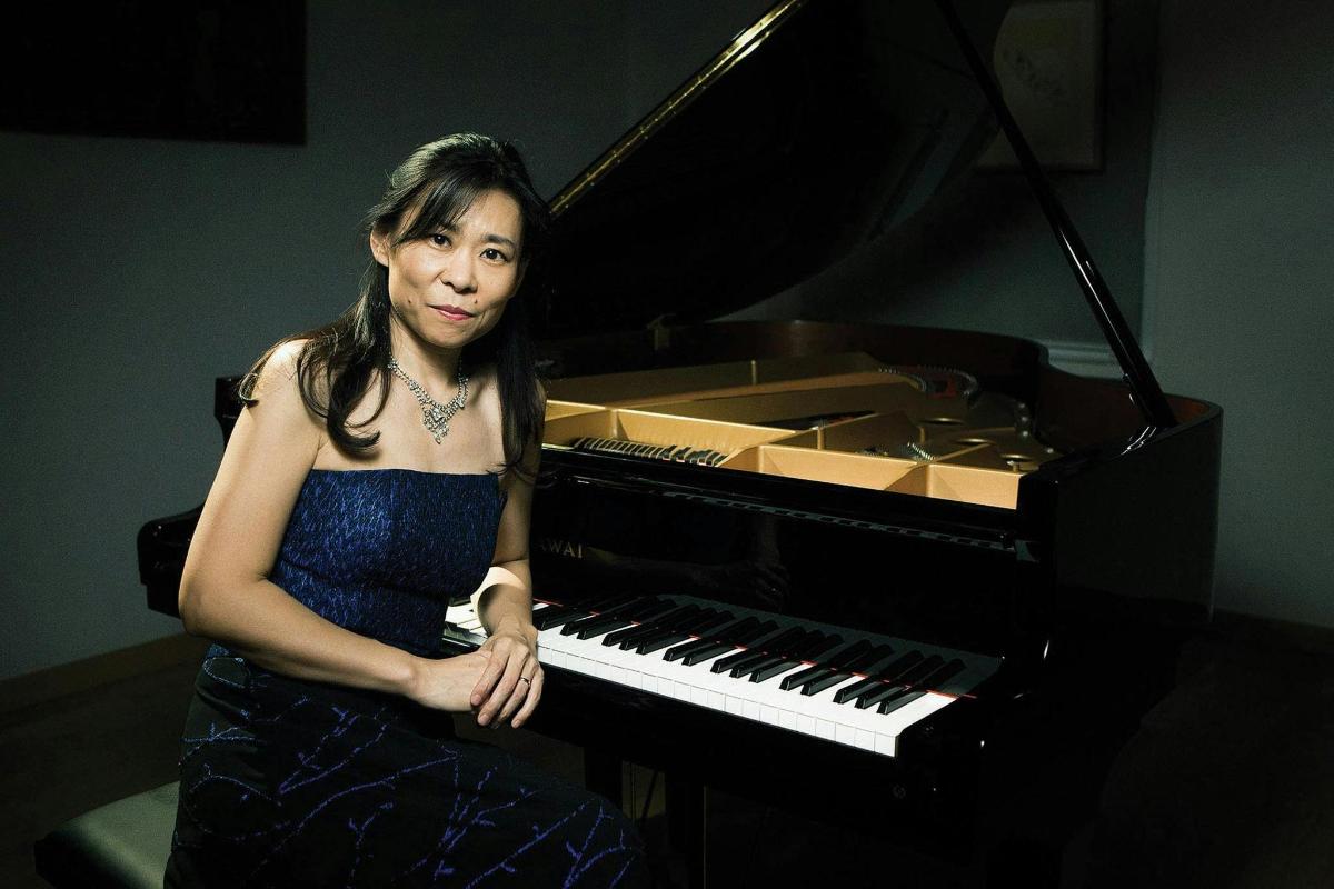 a woman is posing next to a piano
