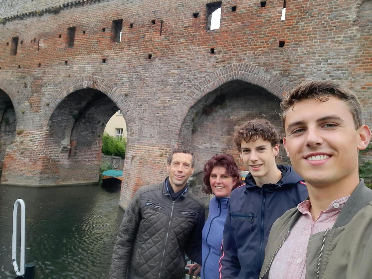 a group of people standing in front of a brick bridge