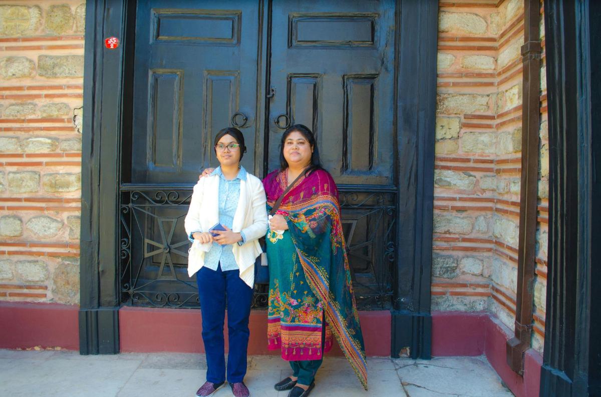 two women are standing in front of a door
