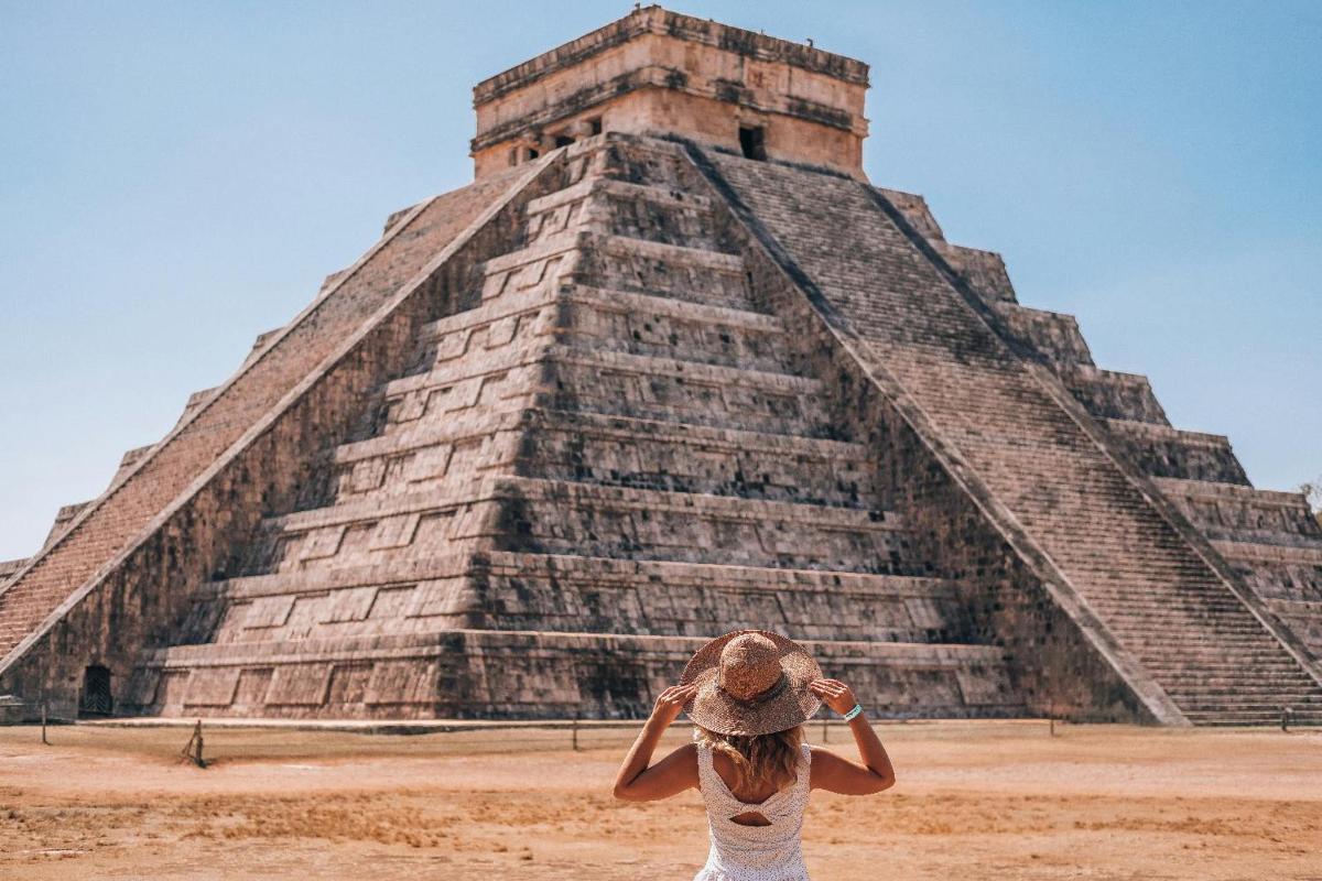 a woman standing in front of a pyramid
