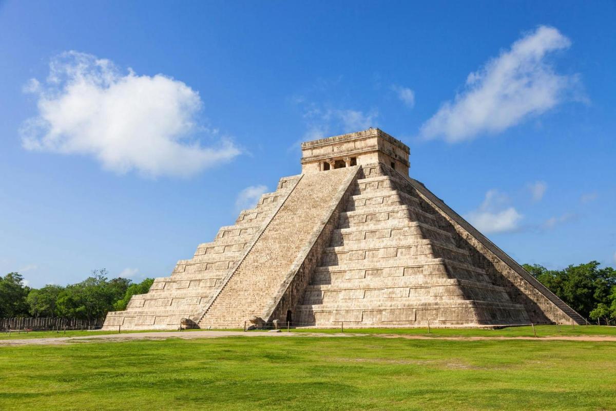 a pyramid in the middle of a grass field