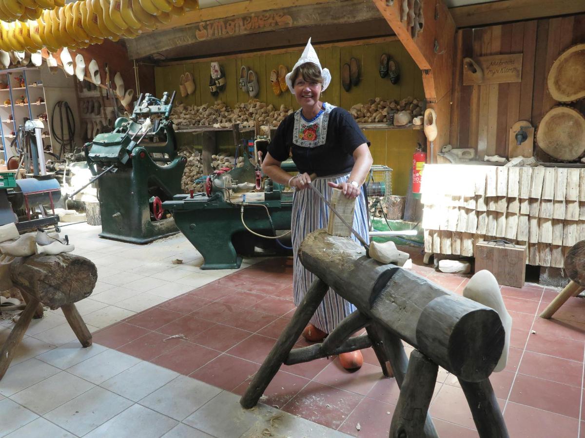 una dona està dreta en una botiga amb un instrument de fusta