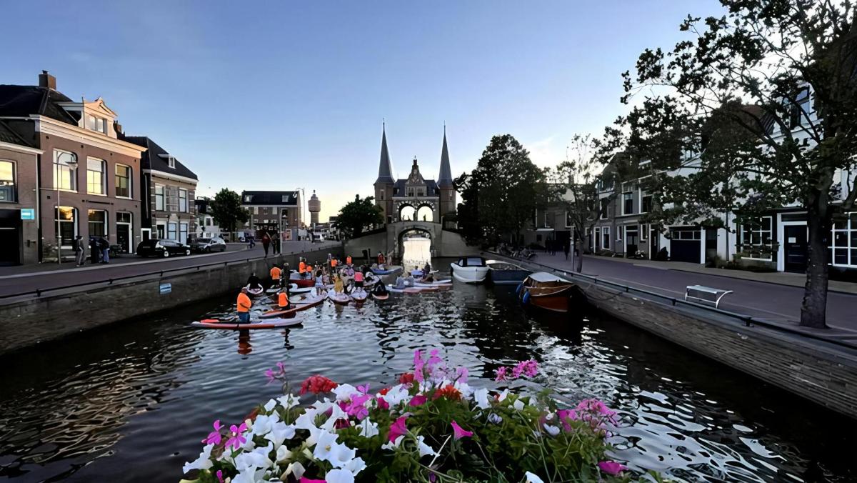 a group of people in boats in a river with flowers