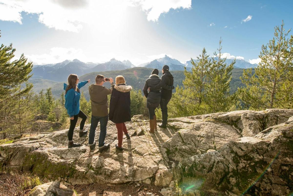 hópur fólks sem stendur uppi á fjallstindi