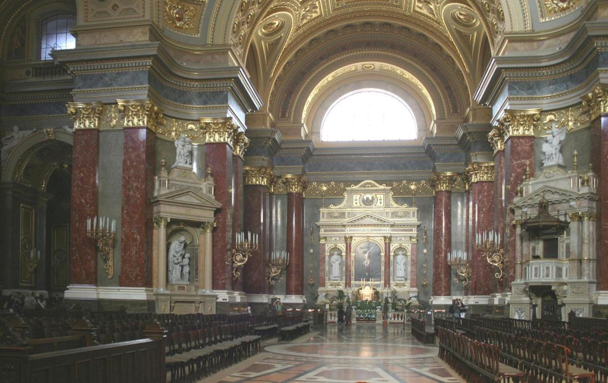 an ornate church with a large room with pews