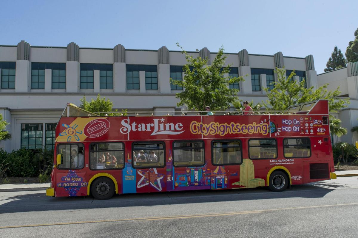červený dvoupatrový autobus zaparkovaný před budovou