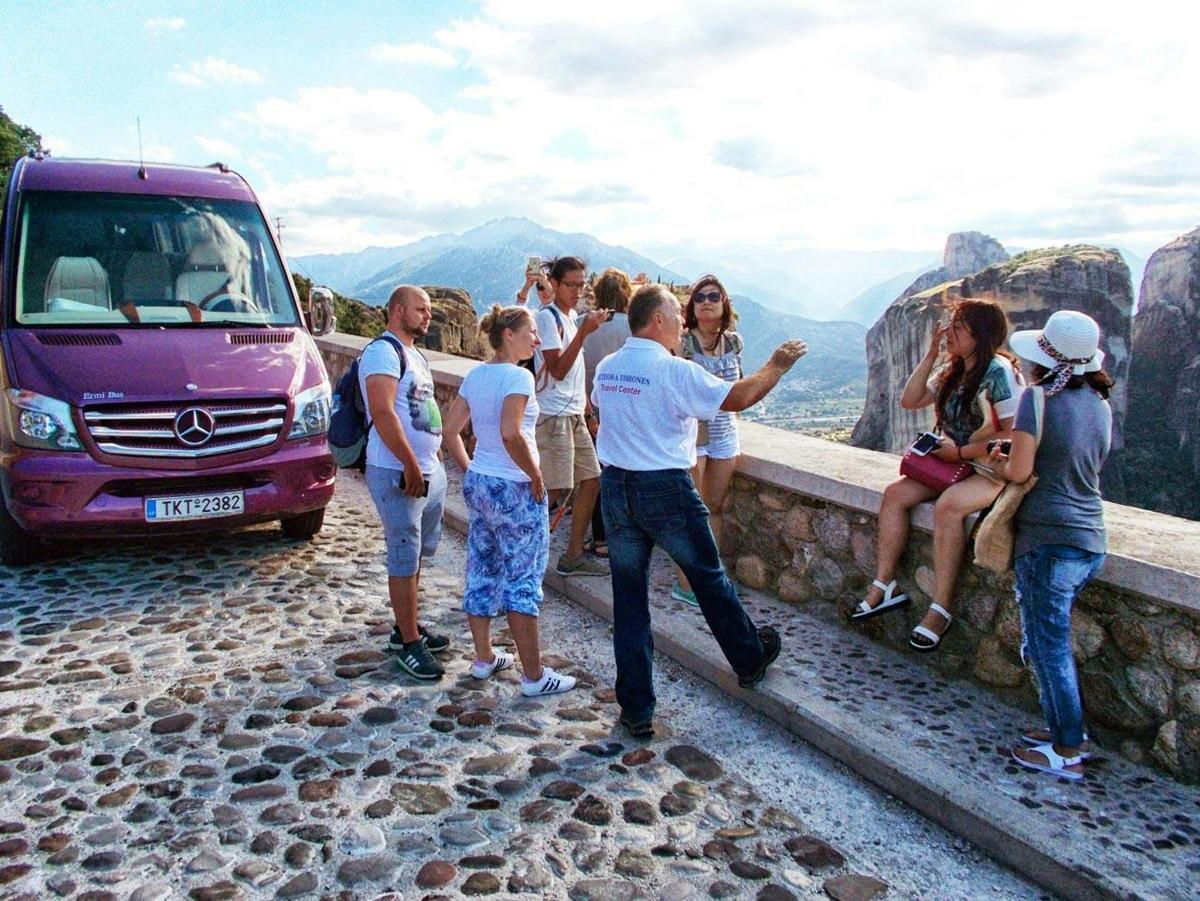 a group of people standing around a van on a mountain