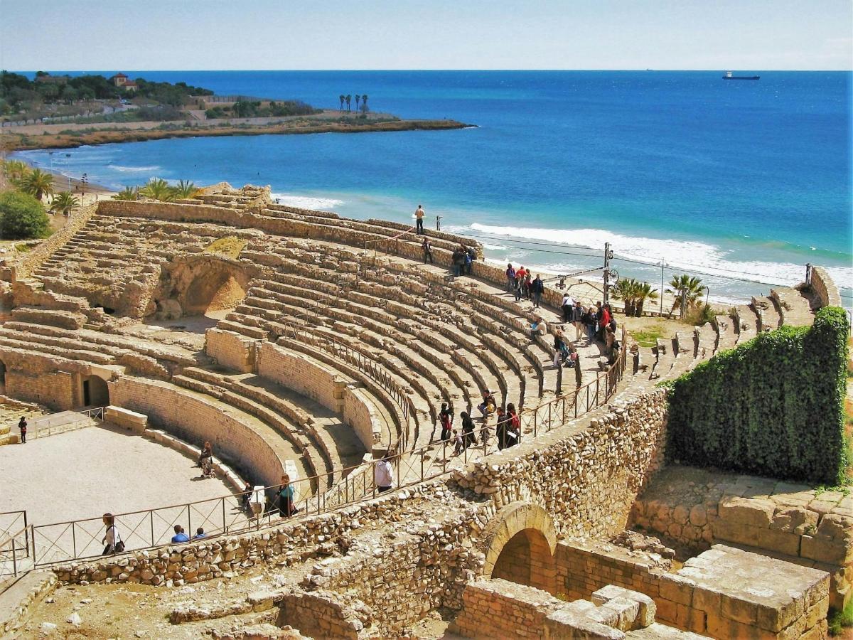 an amphitheater with people walking around in front of the ocean