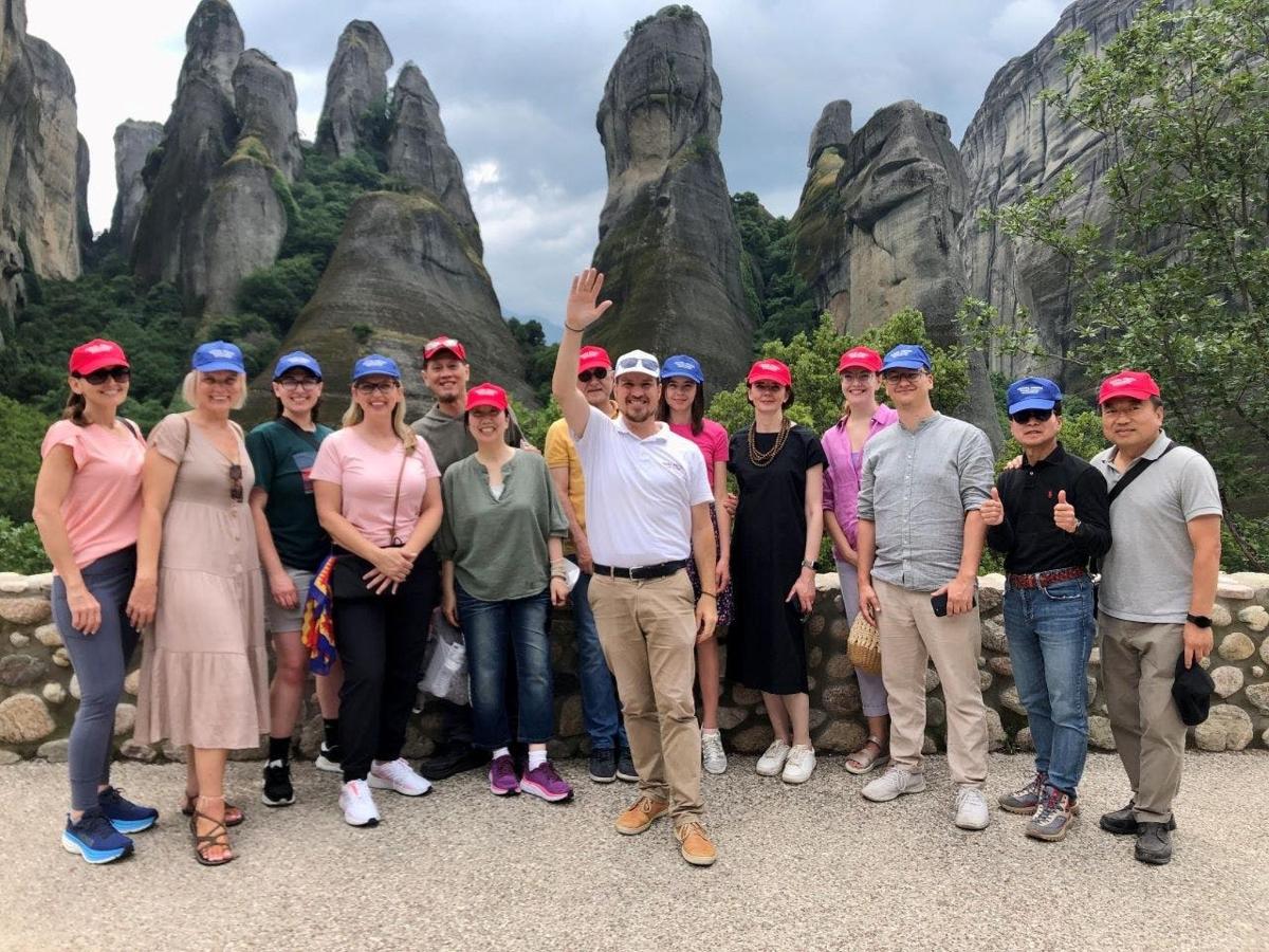 a group of people posing for a picture in front of rock formations