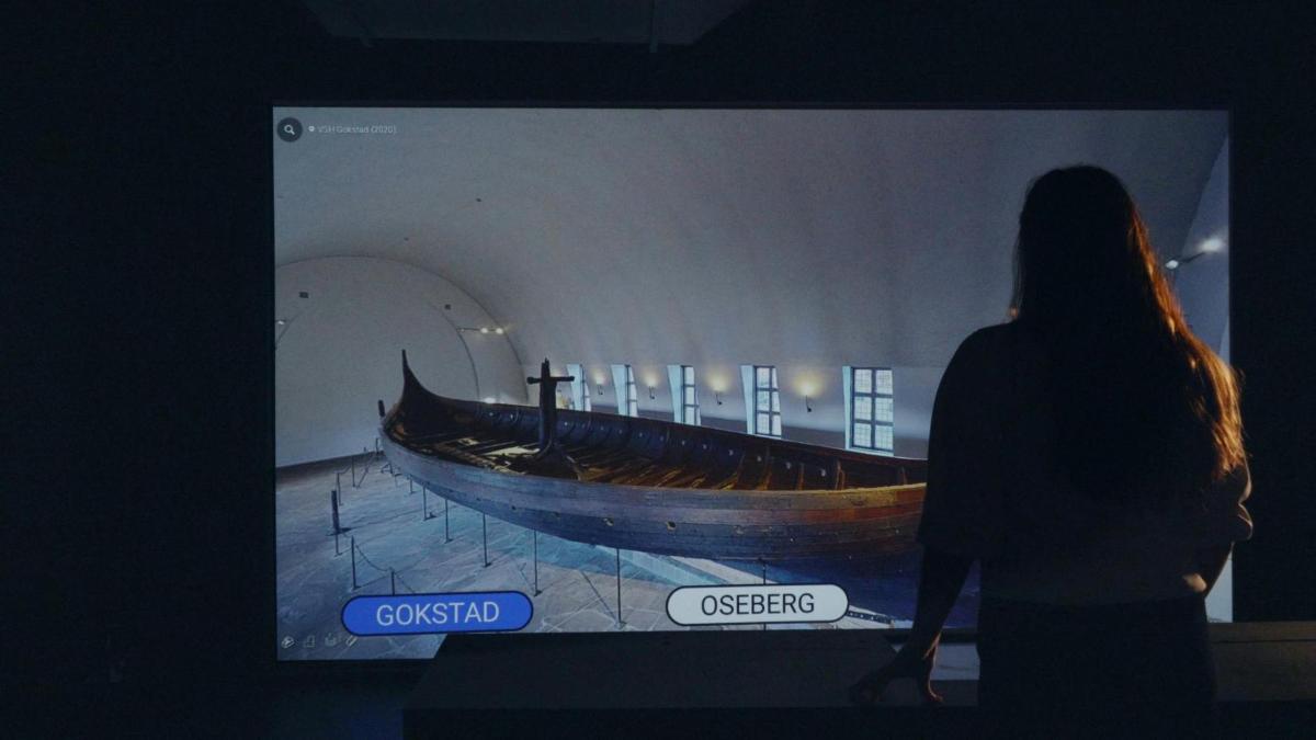a woman looking at a boat in a museum