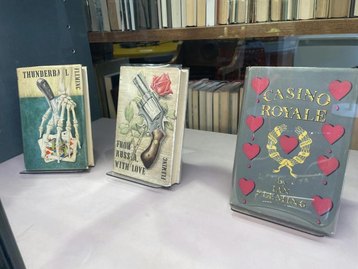 tiga buah buku diletakkan di atas rak