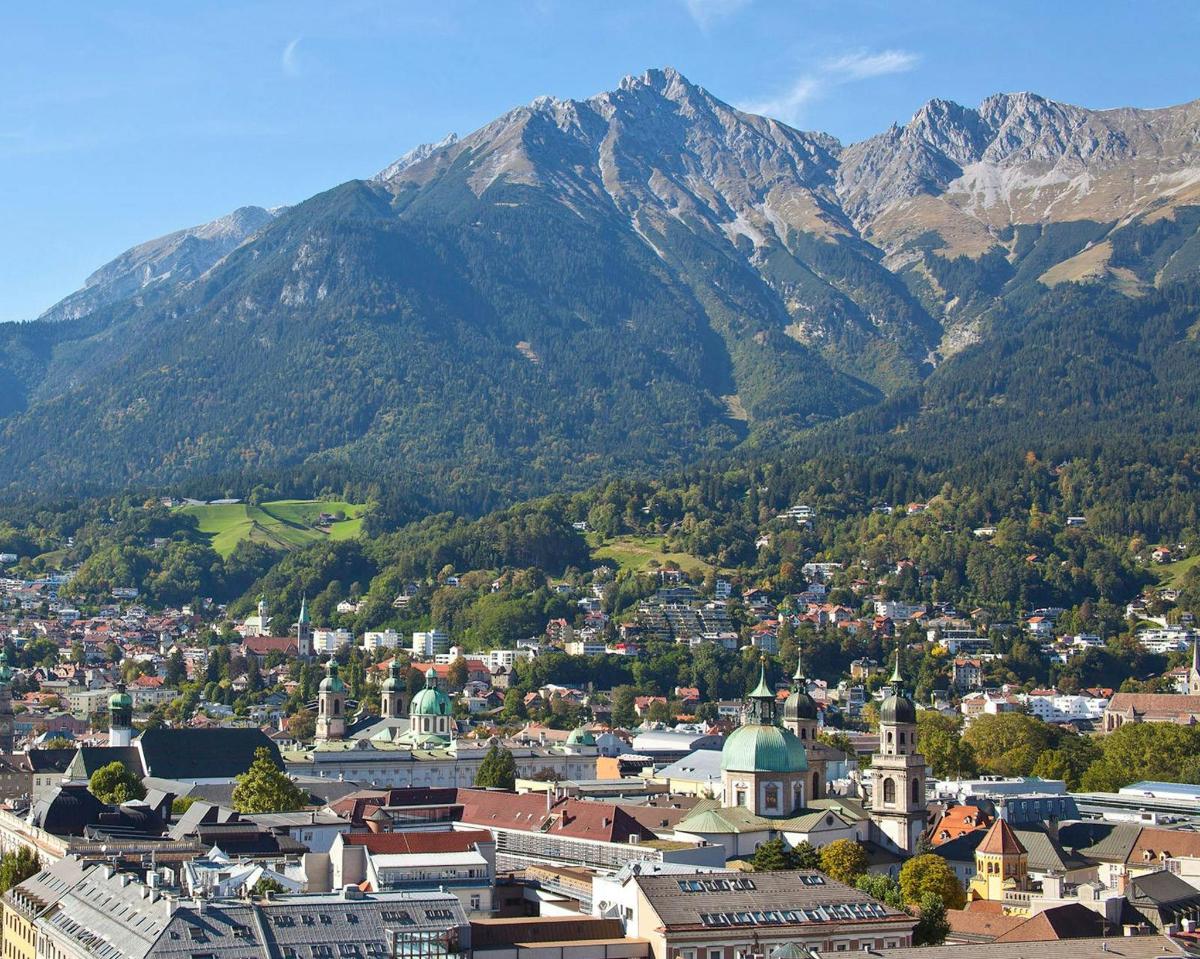 an aerial view of a town with mountains in the background