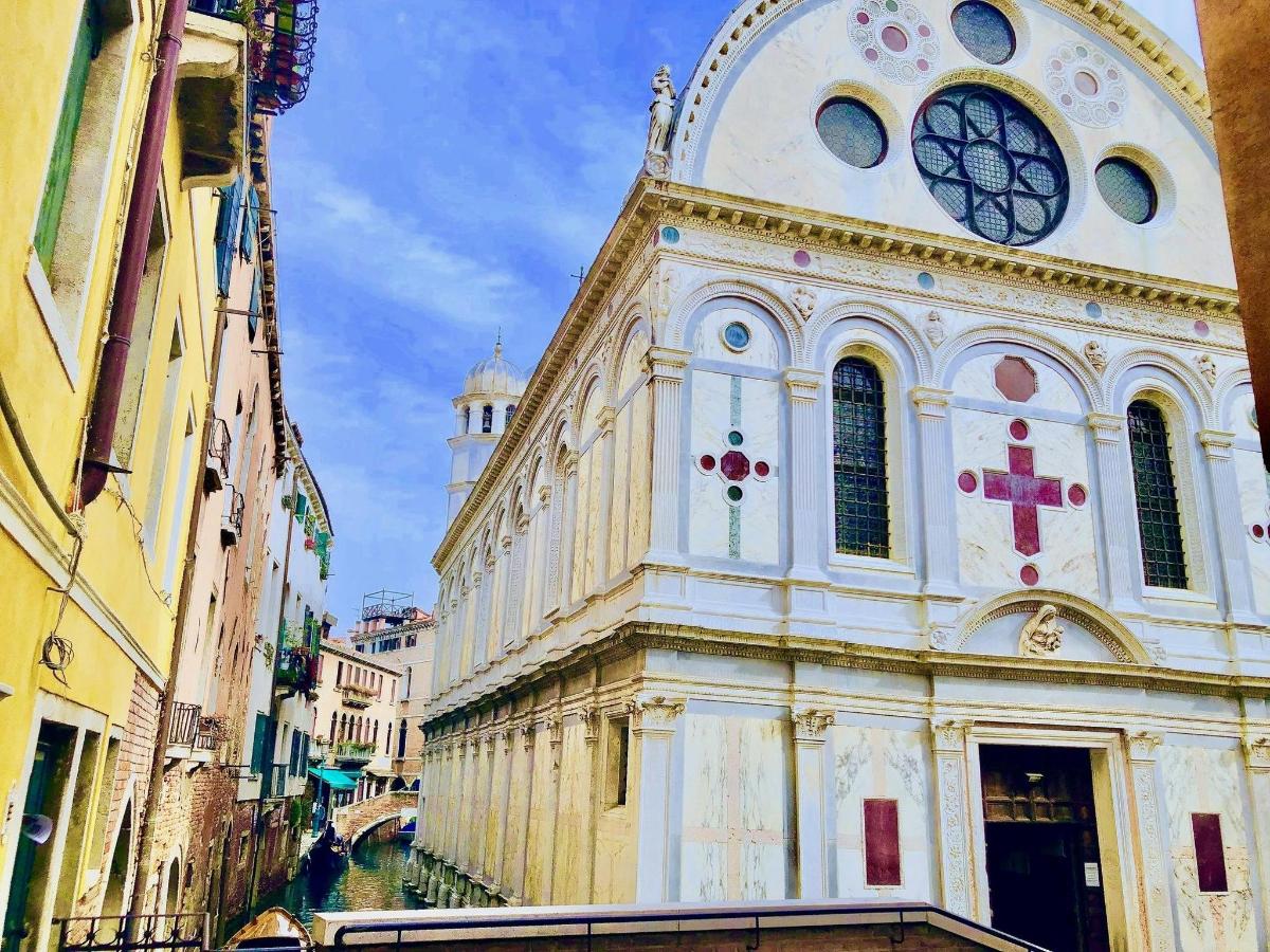 un grande edificio con una torre dell'orologio su una strada