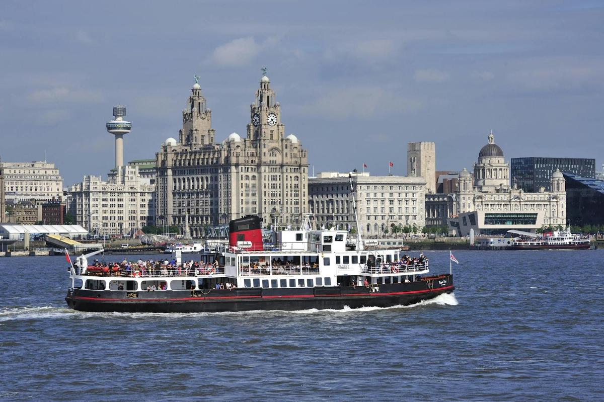 a boat in the water in front of a city