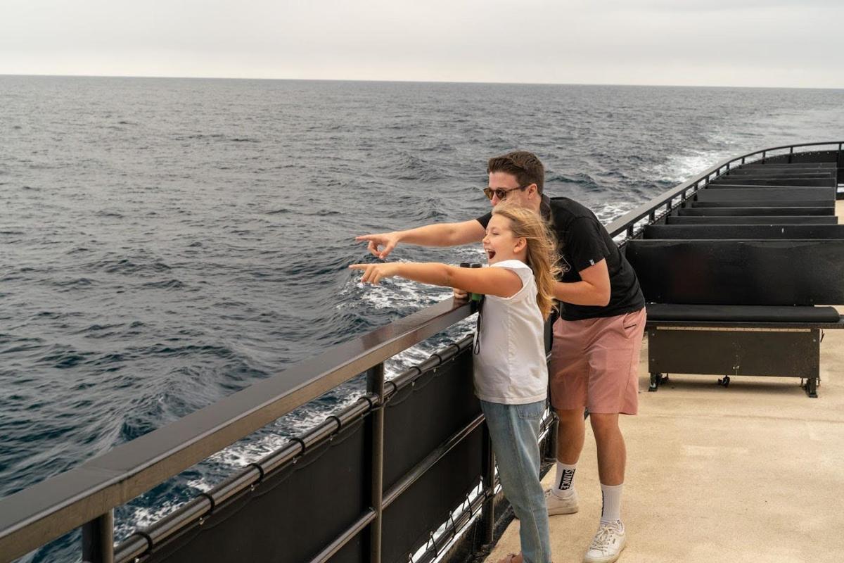 um homem e uma menina parados na lateral de um barco