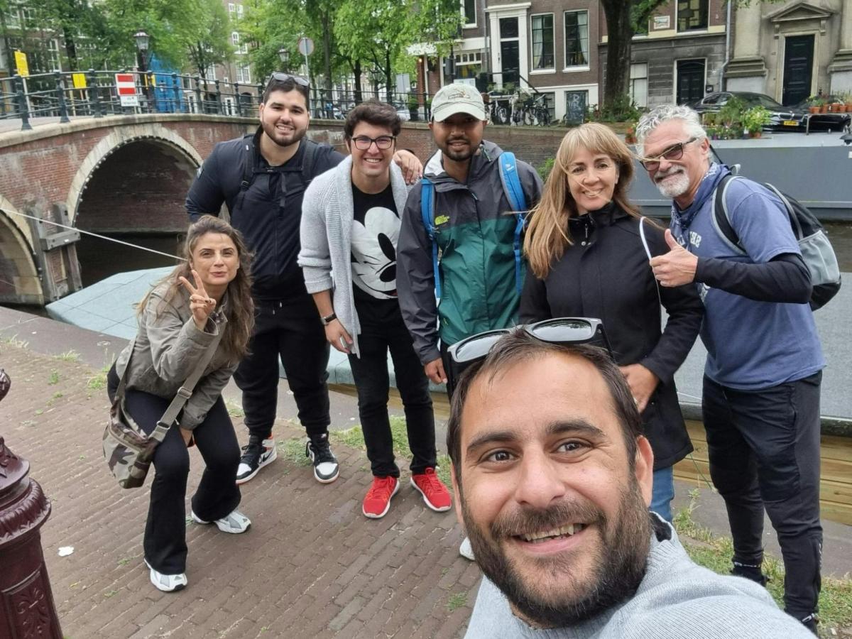 um grupo de pessoas posando para uma foto perto de uma ponte