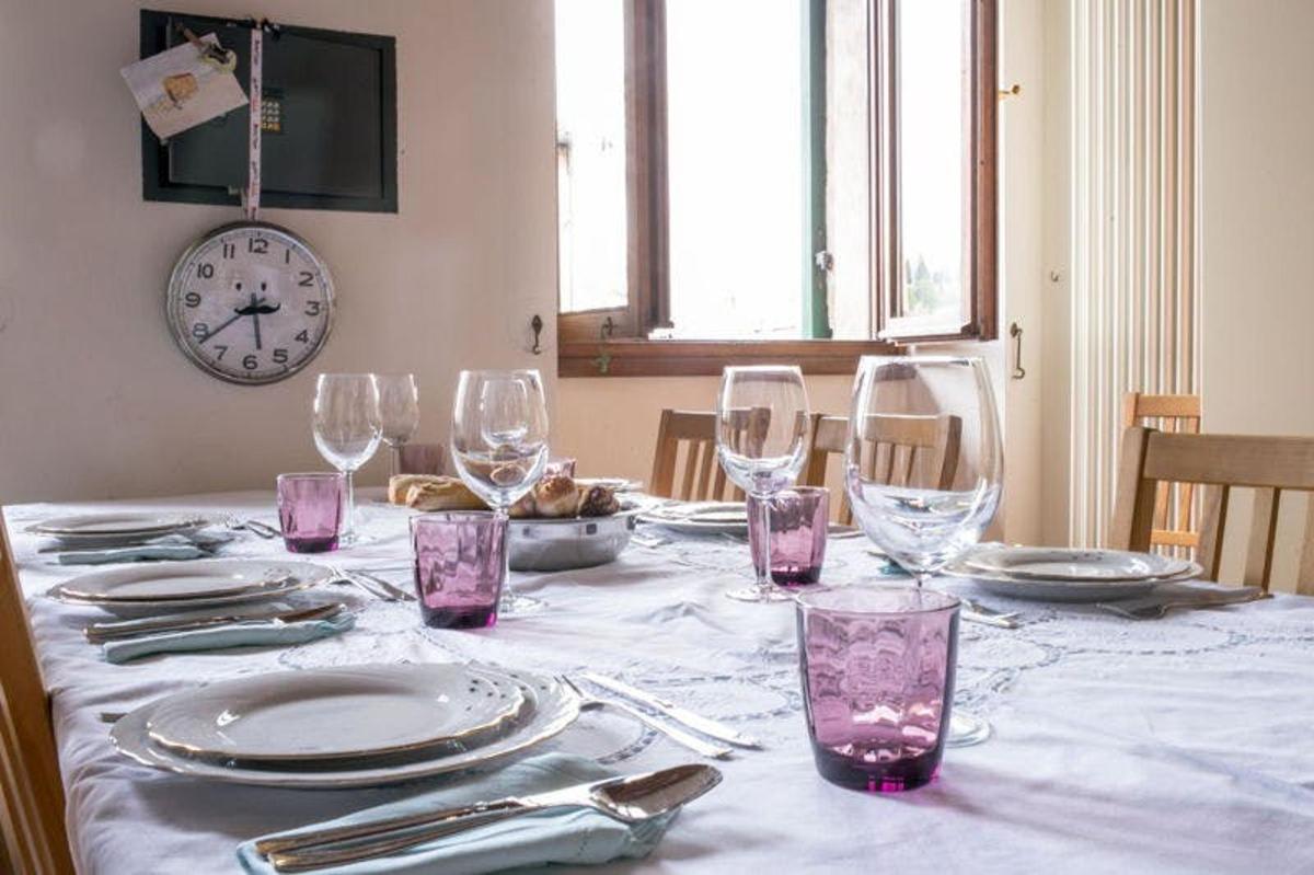 Una mesa con vasos y platos y un reloj en la pared.