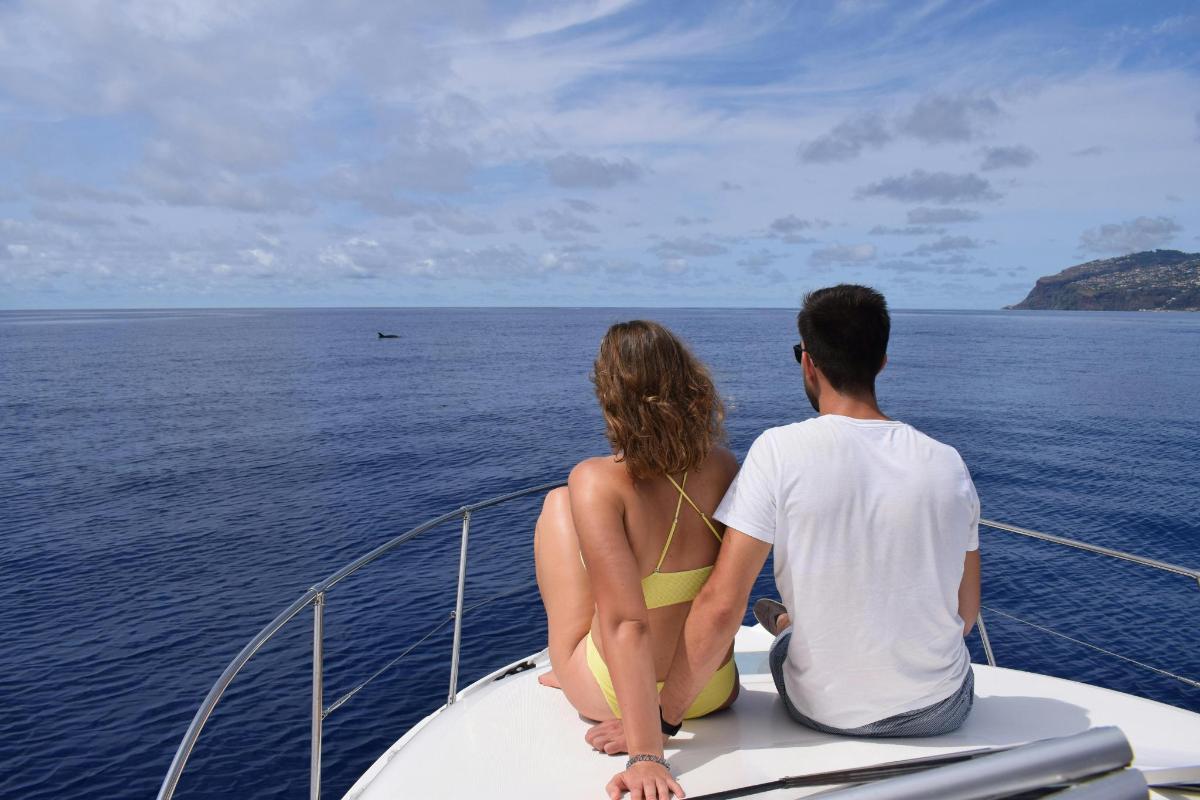 a man and woman sitting on the bow of a boat