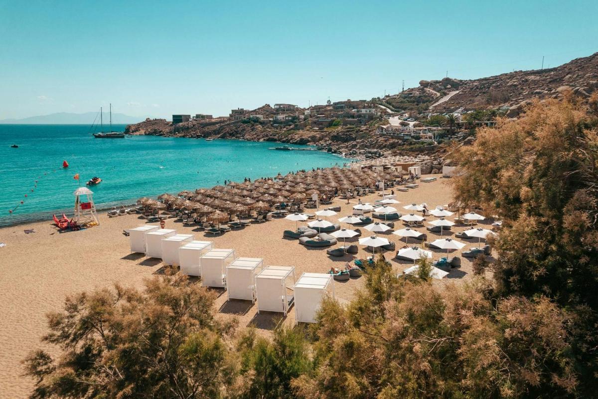 a beach with umbrellas and chairs and the ocean
