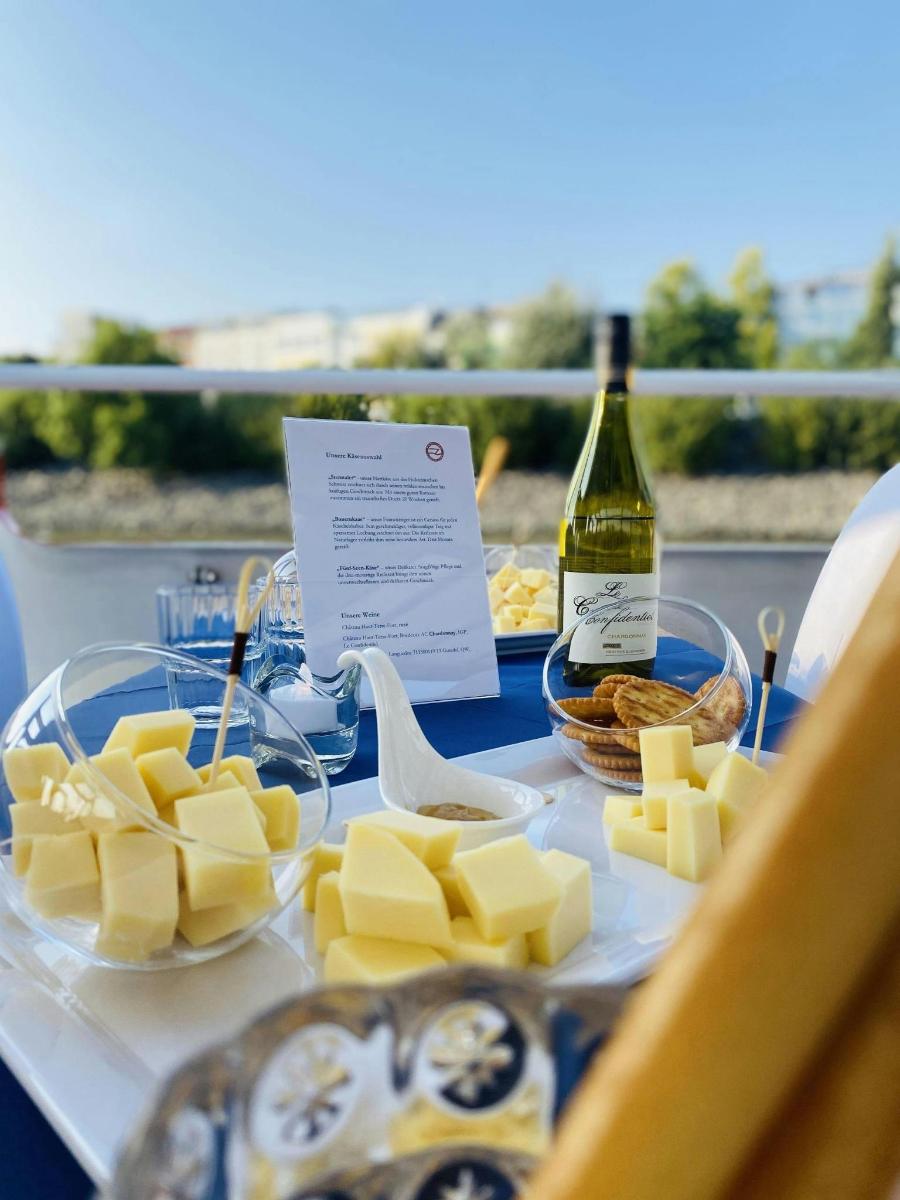 Una mesa cubierta con queso y una botella de vino.