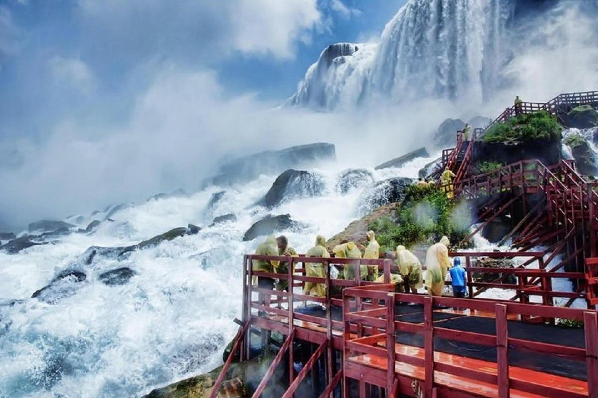 un gruppo di persone in piedi davanti a una cascata