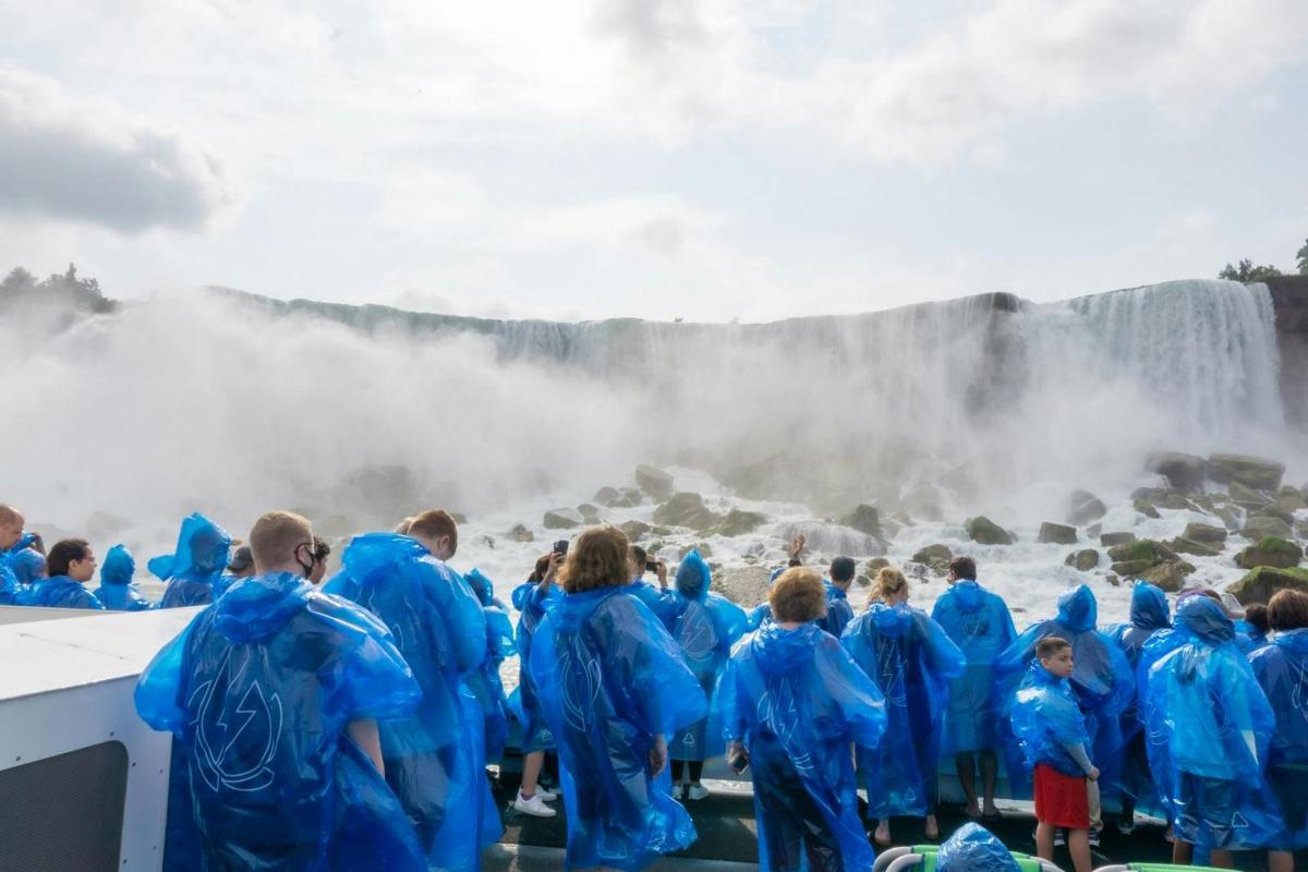 un gruppo di persone in abiti blu in piedi davanti a una cascata