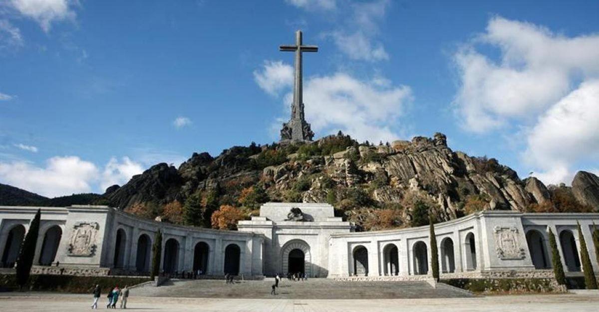 una chiesa con una croce in cima a una collina